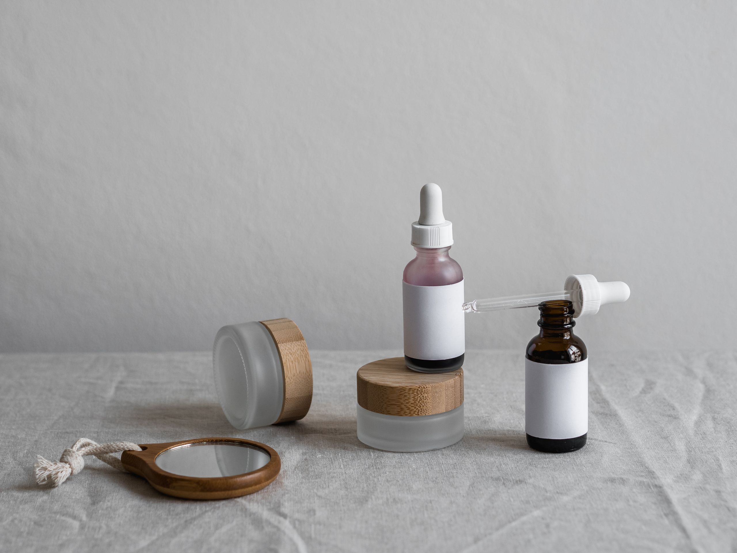 Elegant display of skincare bottles with droppers on a neutral backdrop, perfect for beauty brands.